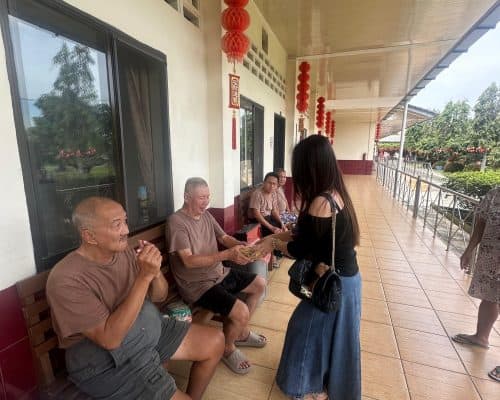 Relawan Lotus Light Charity Society Indonesia berbagi makanan dengan warga lansia.