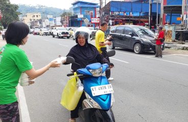 Relawan membagikan makanan kepada pengendara di jalan di Samarinda.