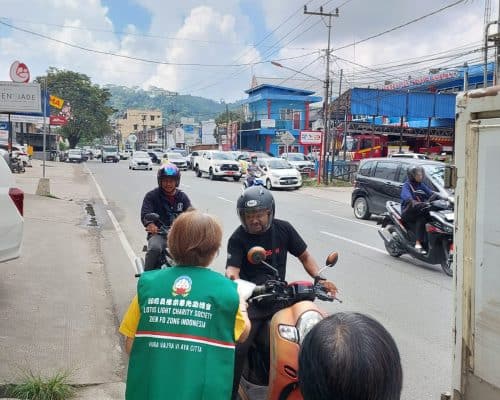 Relawan Lotus Light Charity Society membagikan makanan di jalan kota Samarinda.