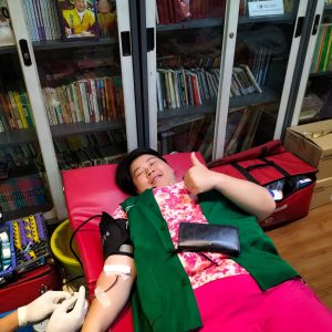 Seorang wanita sedang mendonorkan darah di pusat kesehatan Indonesia.