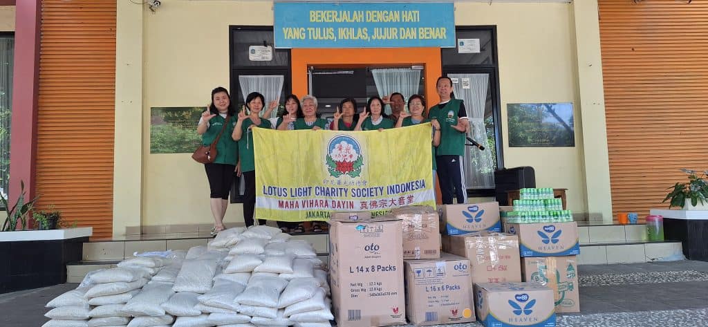 Kelompok relawan Lotus Light Charity Society Indonesia dengan paket bantuan.
