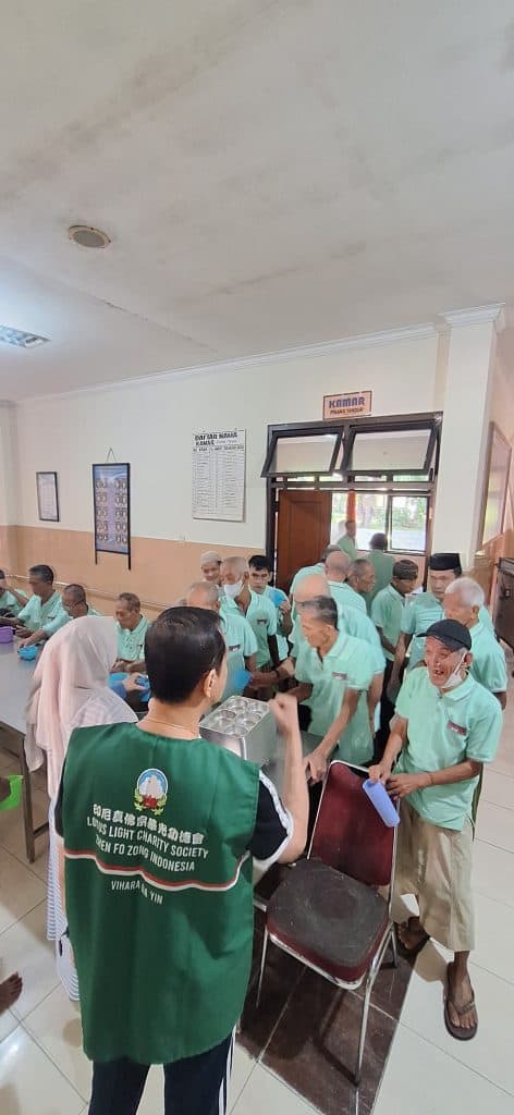 Relawan LLCS membagikan sembako kepada warga selama acara Waisak 2570 BE.
