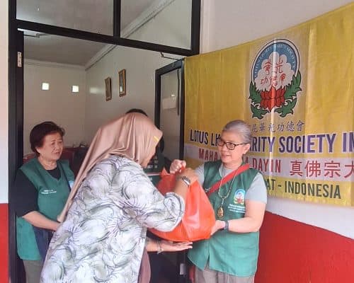 Penerima bantuan menerima paket dari Lotus Light Charity Society Indonesia.