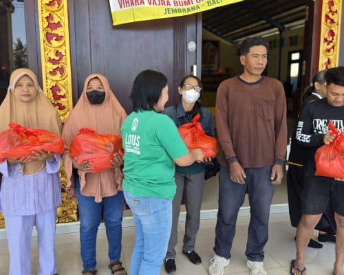 Relawan membagikan paket sembako kepada warga di Bali.