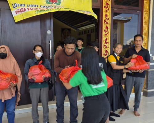 Relawan membagikan paket sembako kepada warga di Bali.
