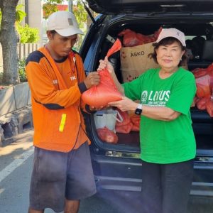 Relawan Lotus Light Charity Society Indonesia membagikan paket bantuan kepada warga.