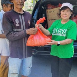 Relawan Lotus Light Charity Society menyerahkan bantuan kepada warga di Indonesia.