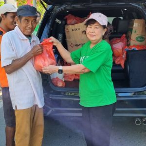 Relawan Lotus Light Charity Society Indonesia bagikan bantuan kepada warga.