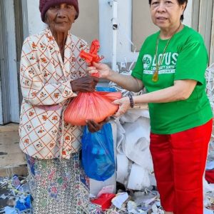 Relawan Lotus Light Charity Society Indonesia menyerahkan bantuan kepada warga lansia.