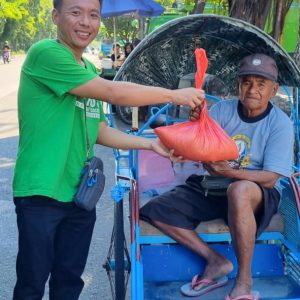 Relawan menyerahkan bantuan kepada penyandang disabilitas di acara sosial.