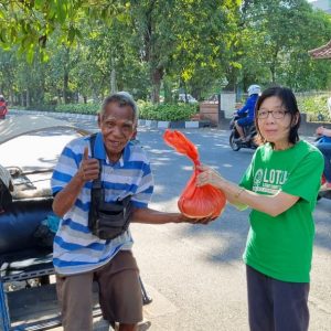 Relawan Lotus Light Charity Society Indonesia membagikan paket bantuan kepada warga.