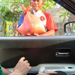 Relawan Lotus Light Charity Society Indonesia membagikan paket sembako kepada warga.