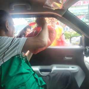 Relawan Lotus Light Charity Society membantu di dalam mobil.