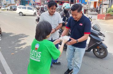 Relawan Lotus Light Society membagikan nasi kepada pejuang nafkah di Samarinda.