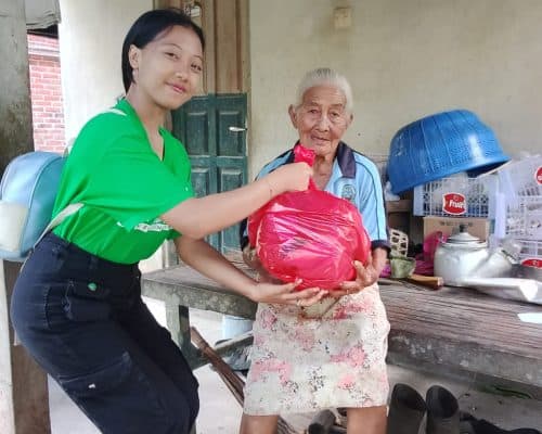 Relawan berbagi kepada lansia dalam kegiatan amal di Bali.
