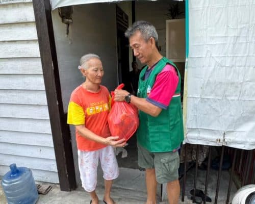 Relawan Lotus Light Charity Society Indonesia bagikan bantuan kepada warga.