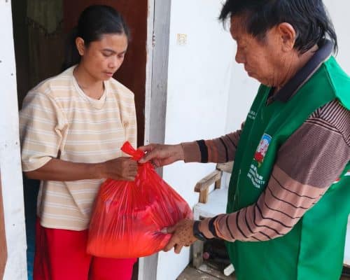 Relawan Lotus Light Charity Society menyerahkan bantuan kepada warga di Indonesia.