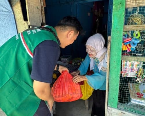 Relawan Lotus Light Charity Society Indonesia membantu distribusi bantuan kepada warga.