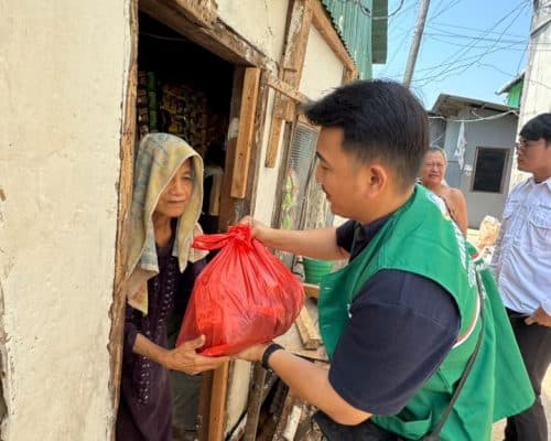 Relawan Lotus Light Charity Society Indonesia memberikan bantuan kepada warga miskin.