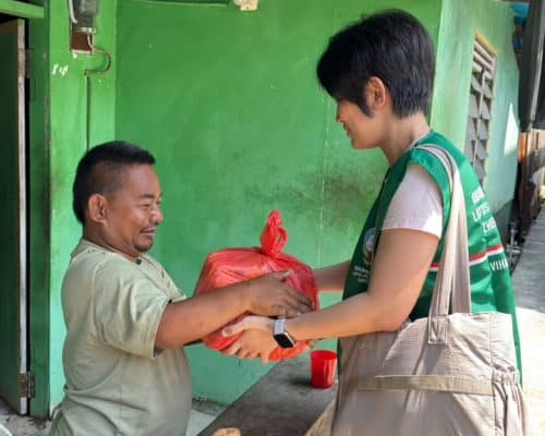 Relawan menyerahkan bantuan kepada warga di Indonesia.